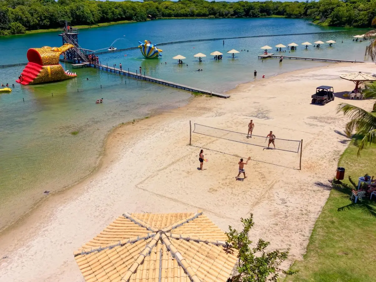 Praia de areia natural com vôlei e toboáguas ao fundo, na Praia da Figueira em Bonito-MS