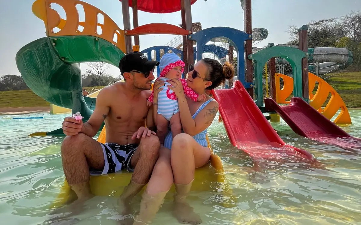 Família com bebê no playground aquático da área kids da Praia da Figueira